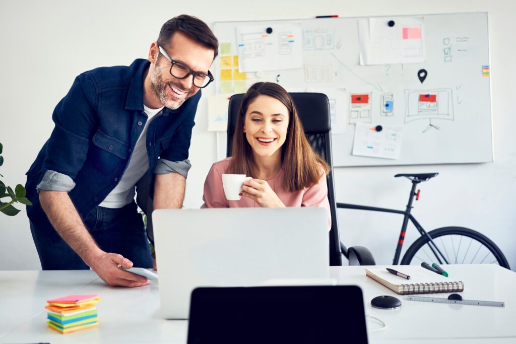 Two colleagues working together on laptop in office